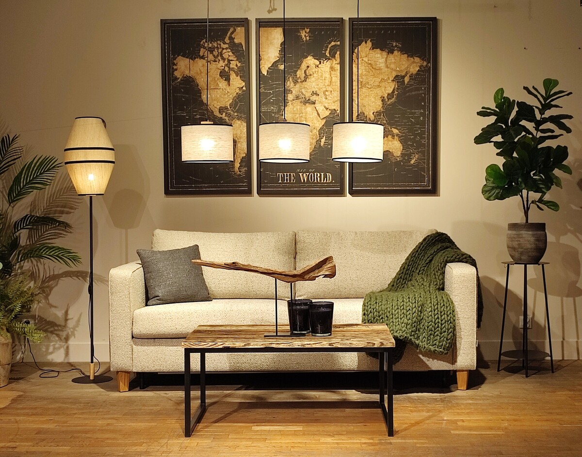 Elegancka sofa w nowoczesnym stylu, miękka tkanina, mapa świata na ścianie, lampa z tkaninowym abażurem, drewniany stolik kawowy, salon z roślinami