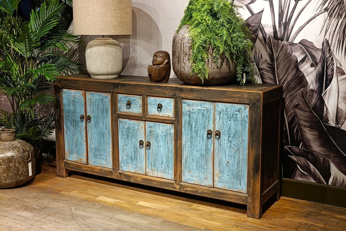 Drewniana komoda na tle czarno-białej tapety, 