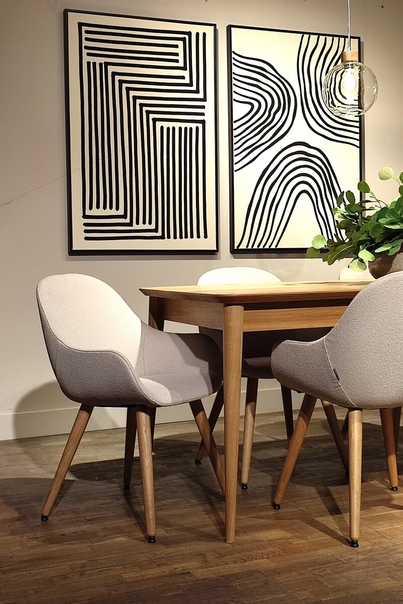 Kremowe krzesła boucle, nowoczesne krzesła podłokietnikami, eleganckie grafiki liniowe, beżowy salon