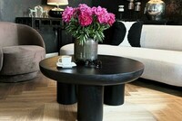 czarny stolik, okrągły stolik, piwonnie, peonie, kwiaty w wazonie, czarna ściana w salonie, brązowy fotel Ava, jasna sofa narożna Aria