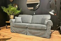 kanapa z pokrowcem do prania, sofa w tkaninie fargotex, czarna lampa podłogowa, duże lustro na sofą, srebrne dodatki w salonie