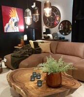 Sofa Zeus w wersji narożnej, w brązowej skórze, unikatowy stolik z blatem z drewna tekowego, lampy industrialne z kolekcji DINING ROOM, obraz z kolekcji ANIMALS