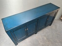 Klasyczna drewniana komoda w niebieskim kolorze.
