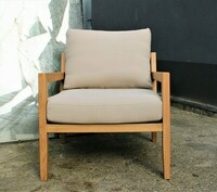 Fotel Karetta w bawełnianej, jasnej tkaninie. Stabilność i trwałość użytkowania zapewnia solidne i bardzo piękne drewno dębowe, z którego została zrobiona konstrukcja mebla. Fotel do wnętrza w stylu boho, fotel na taras, werandę