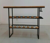 Konsola, barek na wino do salonu. Blat z egzotycznego drewna teak, dwie półki na butelki z frezowanym dębowym frontem, płozy o przekroju 20 x 20 mm w kolorze czarnym, pulverit