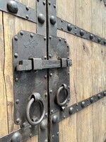 Stare drzwi drewniane z ręcznie wykonanymi stalowymi okuciami. Oryginalna dekoracja wnętrz. Ciekawy zagłówek do łóżka