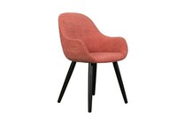 Brzoskwiniowo-różowe krzesło z czarnymi drewnianymi nogami