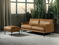 Sofa Ravel w naturalnej brązowej skórze, w zestawie z puf z tej samej kolekcji, smukłe metalowe nogi, nowoczesny design, oferowana w szerokiej gamie tkanin i skór