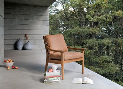 Fotel Revir w brązowej ekskluzywnej skórze naturalnej i dębowej ramie, z wygodnym siedziskiem i oparciem, oraz posiadający ciekawy klasyczny kształt. Doskonała propozycja do współczesnych przestrzeni.