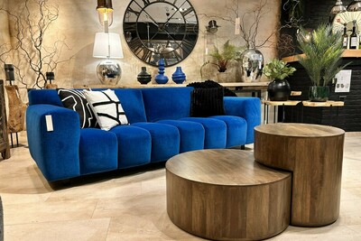 Sofa Vesta Quilt w kolorze kobaltowym. Niebieska sofa welurowa kolor indigo. Kobaltowa sofa welurowa. Duży zegar z lustrem, okrągłe stoliki z drewna mango.