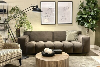 Sofa Vesta Quilt Mti-Furninova w kolorze mocha mousse. Czekoladowa sofa na oliwkowej ścianie w otoczeniu zielonych roślin i dodatków w stylu modern.